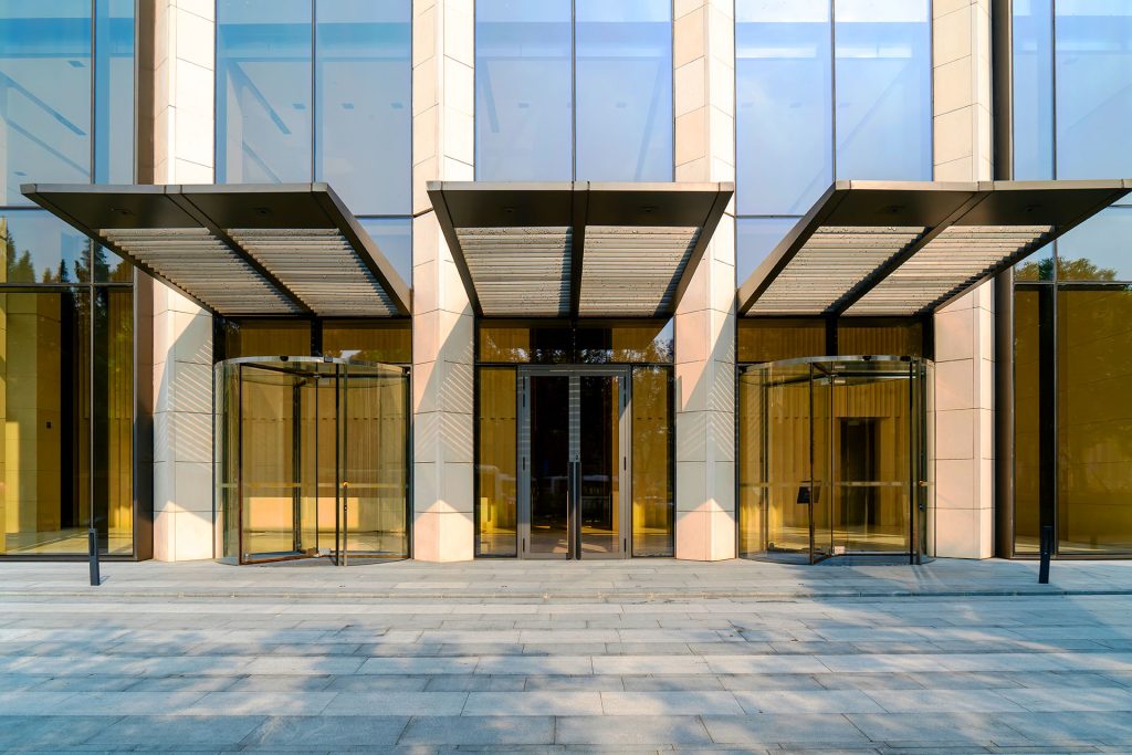 Modern corporate office building exterior with glass revolving doors