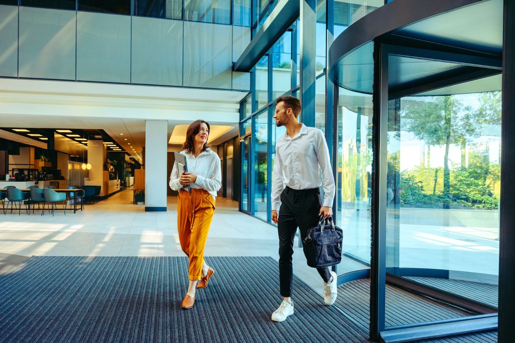Two business professionals walking through modern corporate office lobby